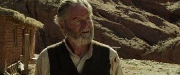 Movie still from “Blackthorn” (2011), directed by Mateo Gil – An old man with a beard and a vest; Close Up shot, Over the shoulder angle