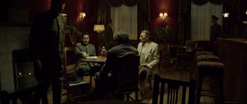 Movie still from “Blackthorn” (2011), directed by Mateo Gil – A group of men sitting around a table in a room; Wide shot, Over the shoulder angle