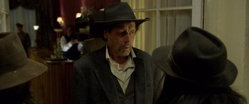 Movie still from “Blackthorn” (2011), directed by Mateo Gil – A man wearing a hat and a suit; Close Up shot, Over the shoulder angle