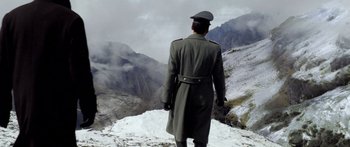 Movie still from “Blackthorn” (2011), directed by Mateo Gil – A man in a military uniform standing on top of a snow covered mountain; Wide shot, Low angle