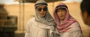 Movie still from “Seoul Vibe” (2022), directed by Hyun-Sung Moon – Two men wearing different colored scarves and sunglasses; Close Up shot, Low angle