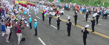 Movie still from “Seoul Vibe” (2022), directed by Hyun-Sung Moon – A group of people marching down a street; Extreme Wide shot, High angle