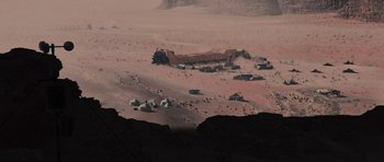 Movie still from “Serenity” (2005), directed by Joss Whedon – An aerial view of a desert area with tents and buildings; Extreme Wide shot, High angle