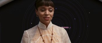 Movie still from “Serenity” (2005), directed by Joss Whedon – A woman in a white shirt and a necklace; Close Up shot, Over the shoulder angle