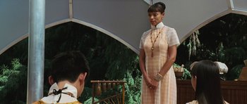 Movie still from “Serenity” (2005), directed by Joss Whedon – A woman standing in front of a man in an orange dress; Medium shot, Over the shoulder angle