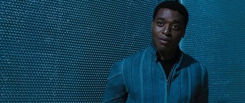 Movie still from “Serenity” (2005), directed by Joss Whedon – A man standing in front of a wall; Close Up shot, Low angle