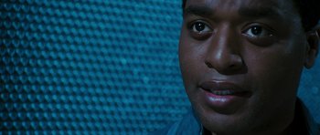 Movie still from “Serenity” (2005), directed by Joss Whedon – A man's face in front of a blue background; Close Up shot, Over the shoulder angle
