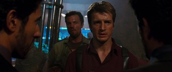 Movie still from “Serenity” (2005), directed by Joss Whedon – Two men standing next to each other on a bus; Close Up shot, Over the shoulder angle