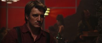 Movie still from “Serenity” (2005), directed by Joss Whedon – A person with a bottle in the background; Close Up shot, Over the shoulder angle