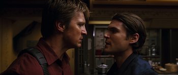 Movie still from “Serenity” (2005), directed by Joss Whedon – A couple of men standing next to each other; Close Up shot, Low angle