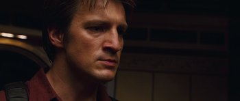 Movie still from “Serenity” (2005), directed by Joss Whedon – A man's face in a dark room; Close Up shot, Low angle