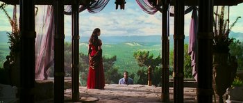Movie still from “Serenity” (2005), directed by Joss Whedon – A woman in a long red dress standing next to a man in front of a fire hydrant; Wide shot, Over the shoulder angle