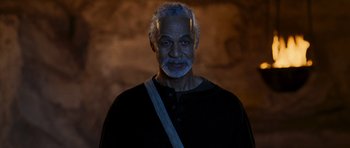 Movie still from “Serenity” (2005), directed by Joss Whedon – An older man with a gray beard is wearing a black shirt; Close Up shot, Low angle