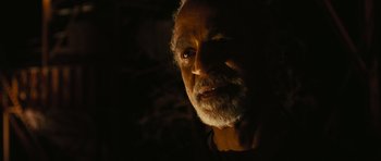 Movie still from “Serenity” (2005), directed by Joss Whedon – An old man with a beard is in the dark; Close Up shot, High angle