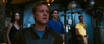 Movie still from “Serenity” (2005), directed by Joss Whedon – A man standing next to another man in a room; Close Up shot, Over the shoulder angle