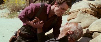 Movie still from “Serenity” (2005), directed by Joss Whedon – A man is helping another man who is lying on the ground; Close Up shot, Over the shoulder angle