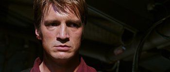 Movie still from “Serenity” (2005), directed by Joss Whedon – A person wearing a red shirt; Close Up shot, Over the shoulder angle