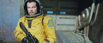 Movie still from “Serenity” (2005), directed by Joss Whedon – A man in a space suit holding a rifle; Medium shot, Low angle