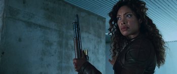 Movie still from “Serenity” (2005), directed by Joss Whedon – A woman holding a gun in a room; Close Up shot, Low angle