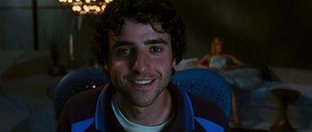 Movie still from “Serenity” (2005), directed by Joss Whedon – A person with curly hair smiling; Close Up shot, Low angle