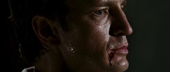 Movie still from “Serenity” (2005), directed by Joss Whedon – A man's face covered in blood; Extreme Close Up shot, Low angle