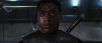 Movie still from “Serenity” (2005), directed by Joss Whedon – A person with a sword in a room; Close Up shot, Low angle