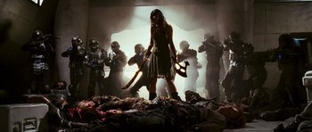 Movie still from “Serenity” (2005), directed by Joss Whedon – A group of people standing in a room holding weapons; Wide shot, Low angle