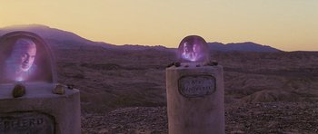 Movie still from “Serenity” (2005), directed by Joss Whedon – A couple is sitting on top of a stone pillar; Wide shot, Over the shoulder angle