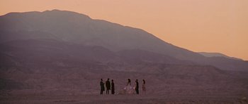 Movie still from “Serenity” (2005), directed by Joss Whedon – A group of people standing in the desert at sunset; Extreme Wide shot, High angle