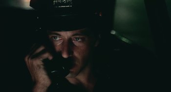 Movie still from “Serpico” (1973), directed by Sidney Lumet – A man in a police hat talking on a cell phone; Close Up shot, High angle