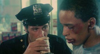 Movie still from “Serpico” (1973), directed by Sidney Lumet – A police officer is drinking a cup of coffee; Close Up shot, Over the shoulder angle
