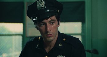 Movie still from “Serpico” (1973), directed by Sidney Lumet – A man wearing a police uniform and a hat; Close Up shot, Low angle
