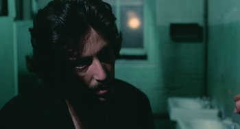 Movie still from “Serpico” (1973), directed by Sidney Lumet – A person in a dark room; Close Up shot, Over the shoulder angle
