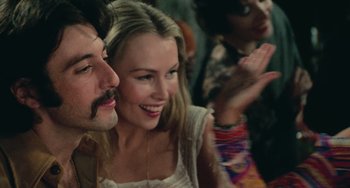 Movie still from “Serpico” (1973), directed by Sidney Lumet – A man and a woman smiling at each other in front of a crowd; Close Up shot, Over the shoulder angle