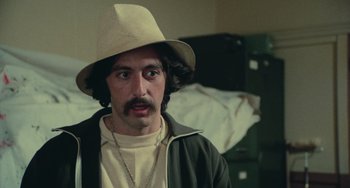Movie still from “Serpico” (1973), directed by Sidney Lumet – A man wearing a hat and a jacket; Close Up shot, Over the shoulder angle