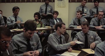 Movie still from “Serpico” (1973), directed by Sidney Lumet – A group of men sitting in a classroom; Medium shot, Over the shoulder angle