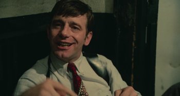 Movie still from “Serpico” (1973), directed by Sidney Lumet – A person wearing a suit and tie; Close Up shot, Over the shoulder angle