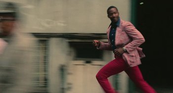 Movie still from “Serpico” (1973), directed by Sidney Lumet – A man in a pink suit is running; Medium shot, High angle