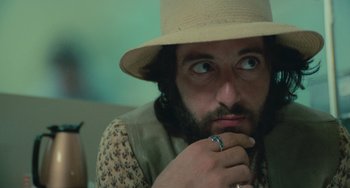 Movie still from “Serpico” (1973), directed by Sidney Lumet – A man with a hat and a beard is looking at the camera; Close Up shot, Low angle