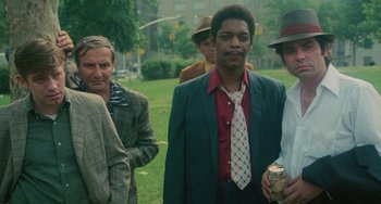 Movie still from “Serpico” (1973), directed by Sidney Lumet – A group of men standing next to each other in a park; Medium shot, Low angle