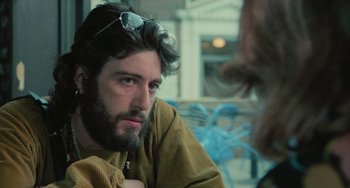 Movie still from “Serpico” (1973), directed by Sidney Lumet – A man with a beard is sitting in front of another man; Close Up shot, Over the shoulder angle