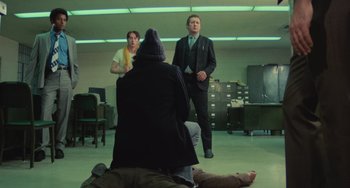 Movie still from “Serpico” (1973), directed by Sidney Lumet – A group of men standing in a room; Wide shot, Low angle