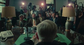 Movie still from “Serpico” (1973), directed by Sidney Lumet – A group of people in a room with cameras and microphones; Wide shot, Over the shoulder angle