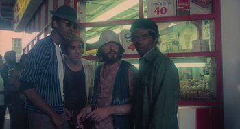 Movie still from “Serpico” (1973), directed by Sidney Lumet – A group of people standing next to each other in a store; Medium shot, Low angle