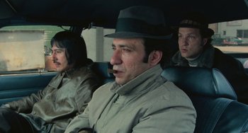 Movie still from “Serpico” (1973), directed by Sidney Lumet – A group of men sitting in the back of a car; Medium shot, Low angle