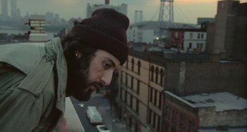 Movie still from “Serpico” (1973), directed by Sidney Lumet – A man with a beard wearing a hat looking out of a window; Close Up shot, Low angle