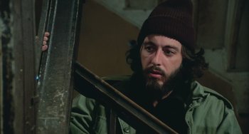 Movie still from “Serpico” (1973), directed by Sidney Lumet – A man with a beard wearing a green jacket and a brown hat; Close Up shot, Low angle