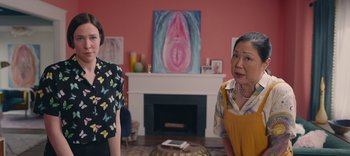 Two people standing in a living room next to a fireplace