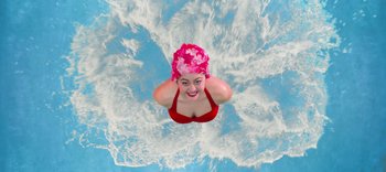 A woman in a red bathing suit and a pink floral hat