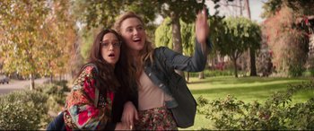 Movie still from “Blockers” (2018), directed by Kay Cannon – Two young women posing for a picture in a park; Medium shot, Low angle